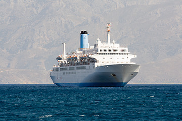 Image showing Tourist cruise sea liner is sailing in rocky bay