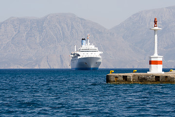 Image showing Tourist cruise sea liner sails to lightship in rocky bay