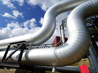 Image showing industrial pipelines on pipe-bridge against blue sky 