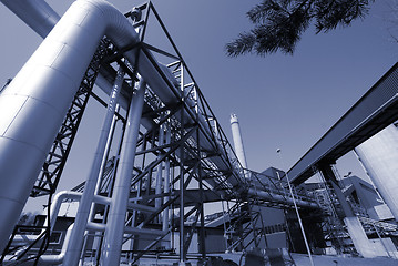 Image showing industrial pipelines on pipe-bridge against blue sky 