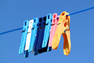 Image showing cloth pegs with a under the blue sky