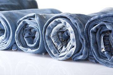 Image showing roll blue denim jeans arranged in line