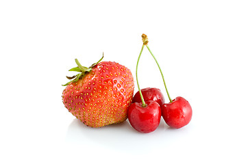 Image showing Single tasty red strawberry and some juicy red cherries