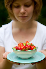 Image showing Girl holding a bowl of strawberries