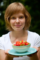 Image showing Girl holding a bowl of strawberries