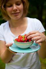 Image showing Girl holding a bowl of strawberries
