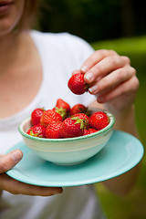 Image showing Girl holding a bowl of strawberries