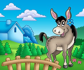 Image showing Donkey with flower behind fence