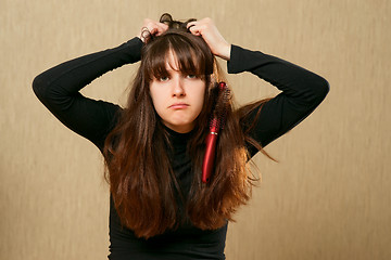 Image showing Hairbrush stucks in female hair