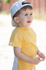 Image showing Little boy in yellow shirt looking sideways