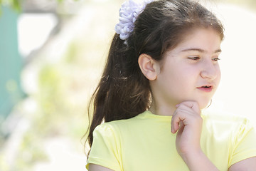 Image showing Pensive brunette girl in yellow shirt