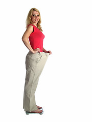 Image showing Girl in big pants on scales