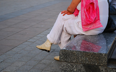 Image showing Woman sitting in a stone bench