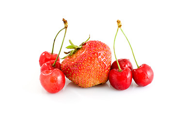 Image showing Single tasty red strawberry and some juicy red cherries