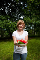 Image showing Girl holding a bowl of tomato and cucumber