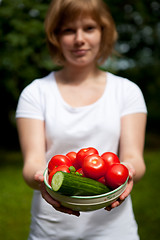 Image showing Girl holding a bowl of tomato and cucumber