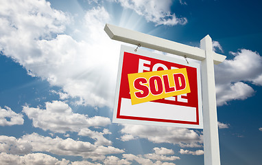 Image showing Sold For Sale Real Estate Sign over Clouds and Blue Sky