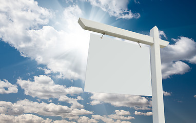 Image showing Blank Real Estate Sign over Clouds and Blue Sky