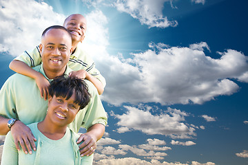 Image showing Happy African American Family Over Blue Sky and Clouds