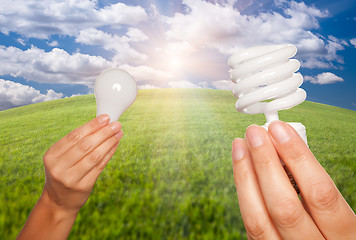 Image showing Female Hands Holding Energy Saving and Regular Light Bulbs 