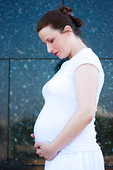 Image showing Beautiful young pregnant girl looking at her belly