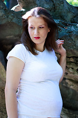 Image showing Beautiful young pregnant girl with stones in the background