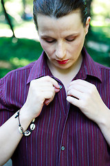 Image showing Beautiful young woman buttoning