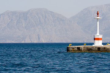 Image showing Lighthouse in rocky bay against the background of mountain