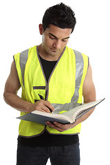 Image showing Builder writing in a book
