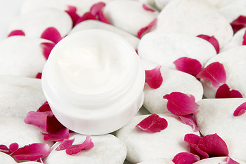 Image showing stones and red rose petals background for beauty cream