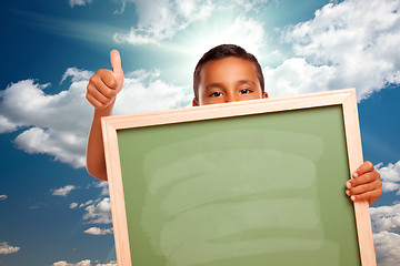Image showing Proud Hispanic Boy Holding Blank Chalkboard Over Sky
