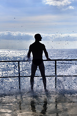 Image showing Silhouette of young man standing at the seaside