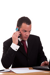 Image showing businessman setting a desk talking on the phone