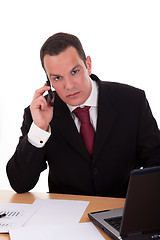 Image showing businessman setting a desk talking on the phone