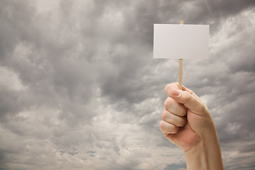 Image showing Man Holding Blank Sign Over Dramatic Storm Clouds