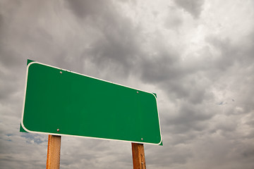 Image showing Blank Green Road Sign Over Storm Clouds