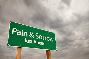 Image showing Pain and Sorrow Green Road Sign Over Storm Clouds