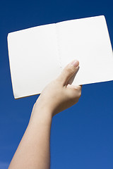 Image showing Hand on sky,holding a book