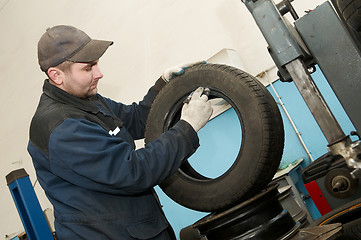 Image showing repairman lubricating car tyre