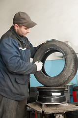 Image showing repairman lubricating car tyre