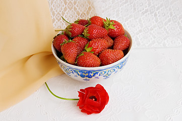 Image showing Dishes with strawberries and a flower