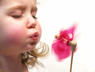 Image showing girl blowing pinwheel