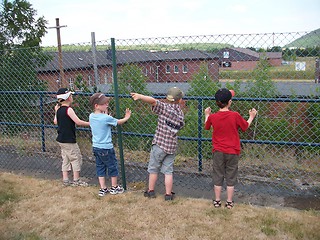 Image showing Children with interest look through a fence