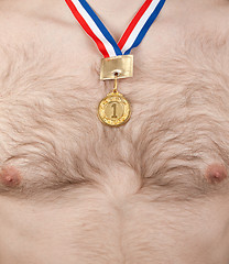 Image showing Nude male thorax with hair and golden medal