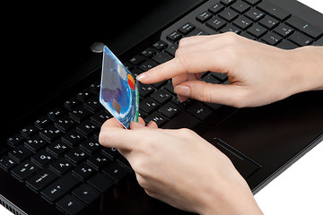 Image showing Feminine hands with bank card on keyboard