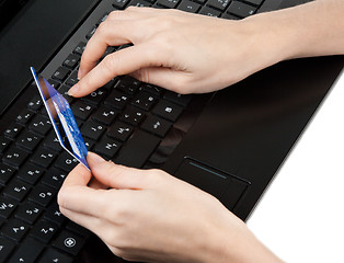 Image showing Feminine hands with bank card on keyboard