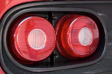 Image showing Closeup shot of a tail light on red sports car. 