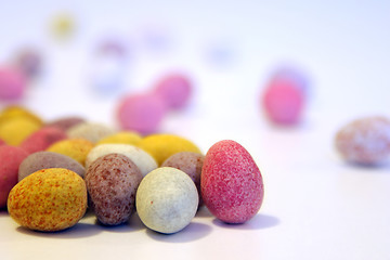 Image showing Mini candy chocolate eggs on a white surface