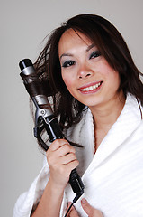 Image showing Girl curling her hair.