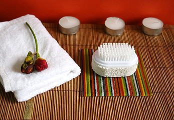 Image showing Pumice brush, candles and towel at a spa - health and beauty